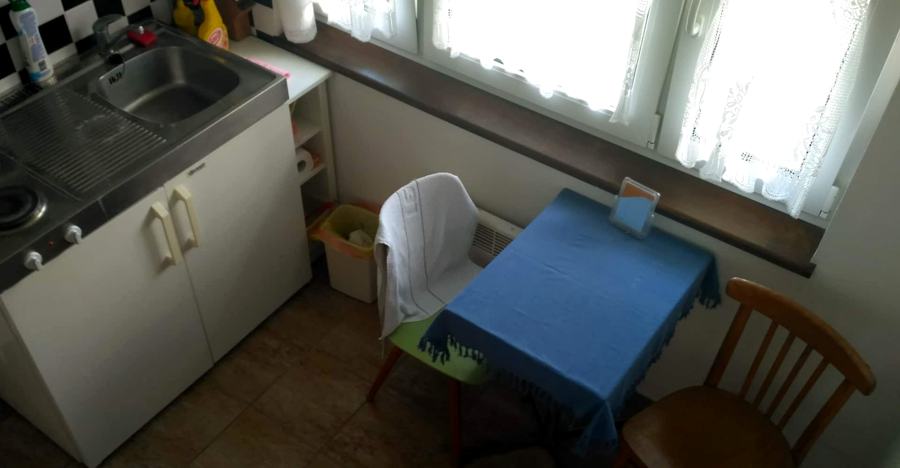Stolek s modrým ubrusem a dvě židle u okna